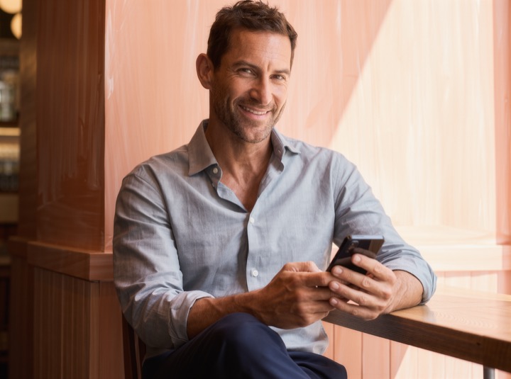 Man smiling at his smartphone (illustrative image)